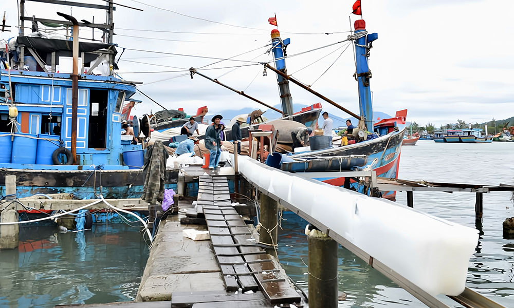 Loading block ice onto a fishing boat for deep-sea seafood preservation